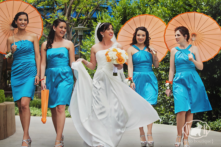 blue bridesmaid dresses with orange parasols that pop