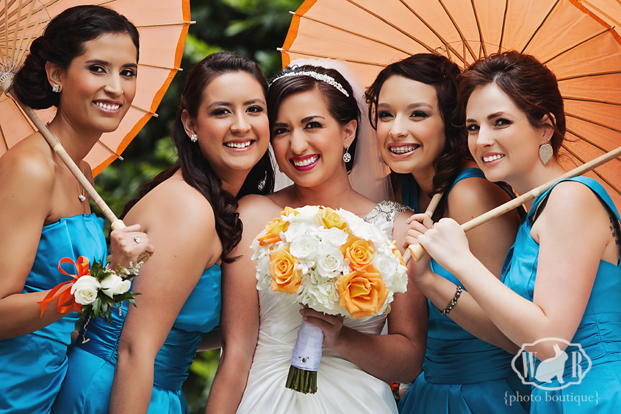 blue bridesmaid dresses with orange parasols that pop