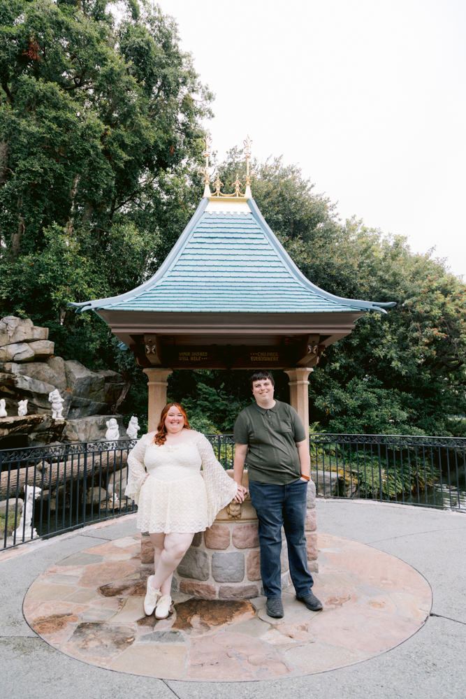 Disneyland engagement session with candid at moments at snow whites wishing well