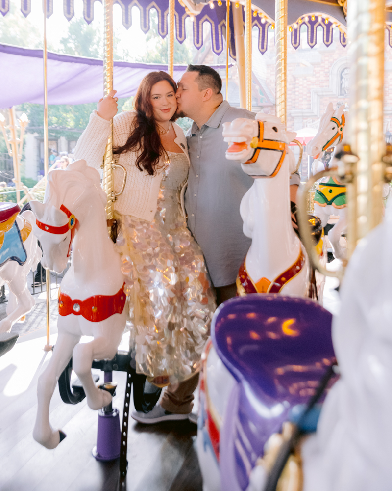 Romantic engagement photos taken inside Disneyland Park on the carousel