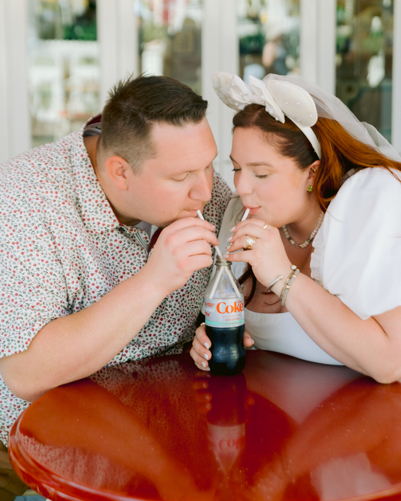 Disneyland engagement photos with Coca-Cola bottle and classic snacks and churros