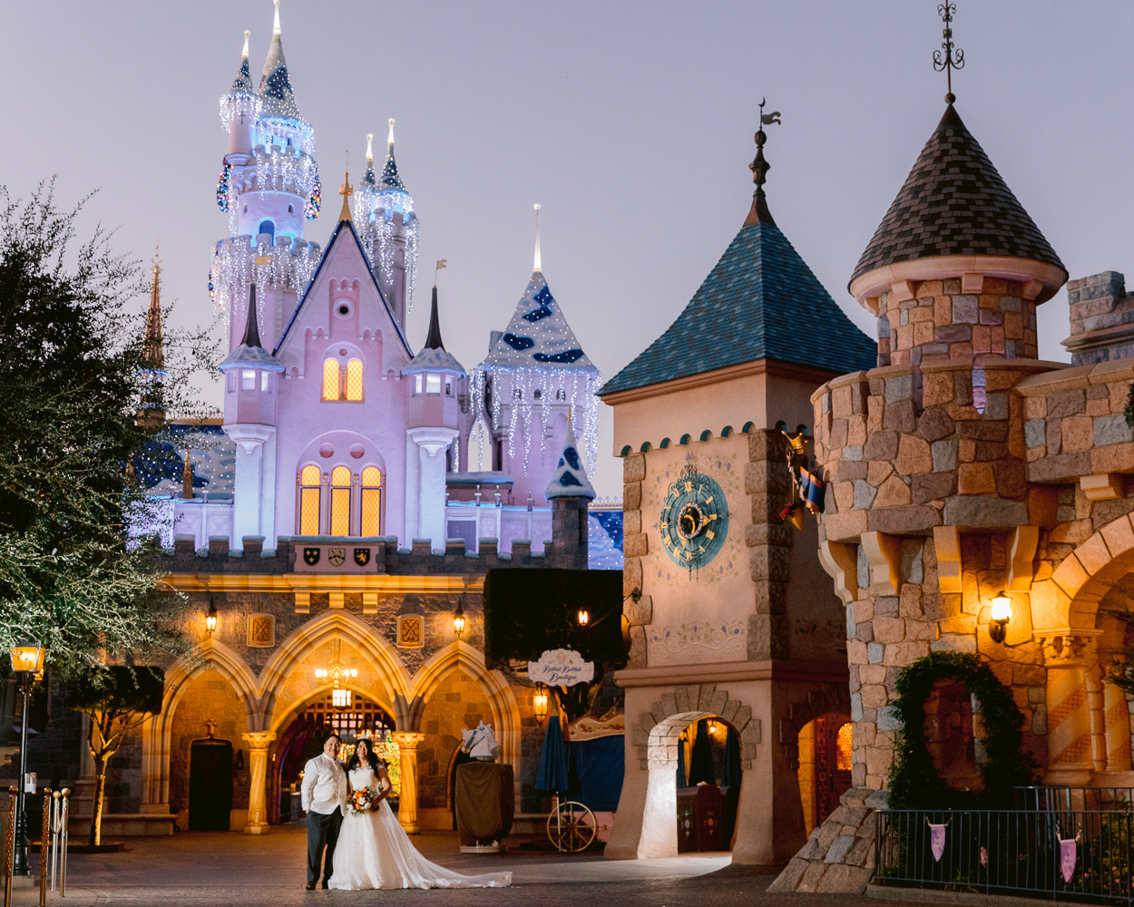 Disney Wedding castle portrait session at Disneyland with Christmas lights on Sleeping Beauty Castle