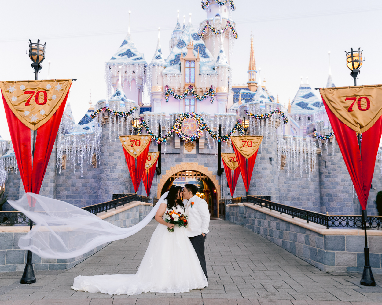 Disney Wedding castle portrait session at Disneyland with Christmas lights on Sleeping Beauty Castle
